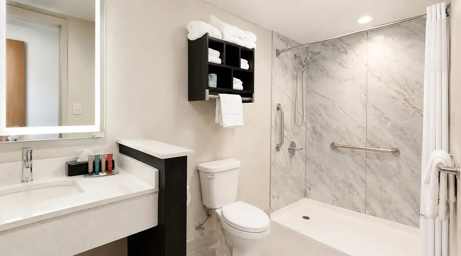 Accessible bathroom with grab bars and roll-in shower in ADA king room at Lx Hotel Manchester TN