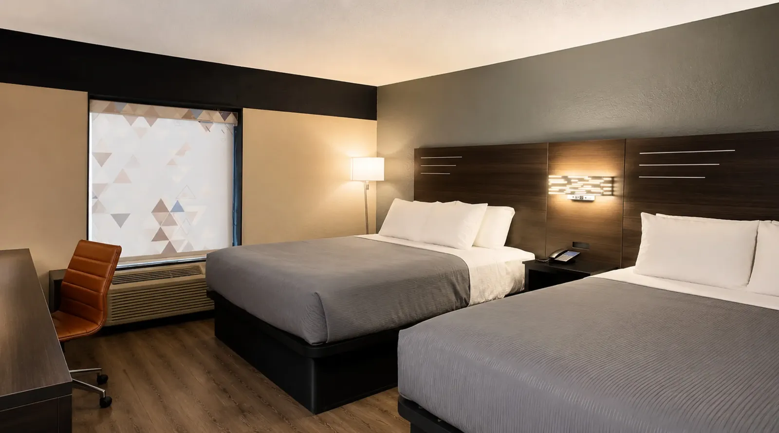 Double queen room at Lx Hotel Manchester TN with seating area and television