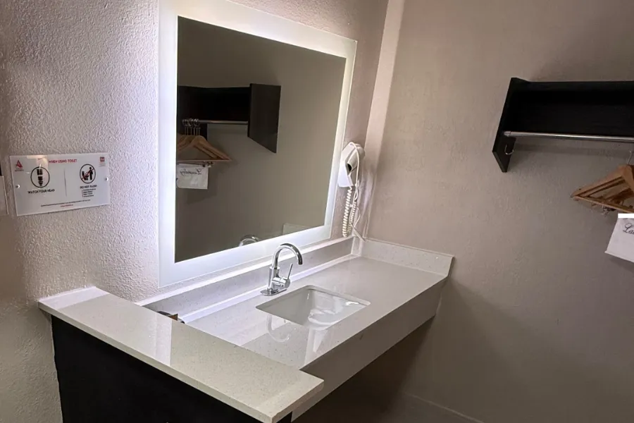 Double queen room bathroom at Lx Hotel with vanity and shower